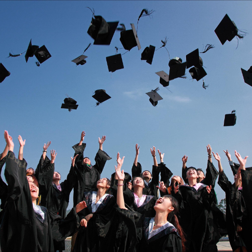 college graduates throwing graduation caps