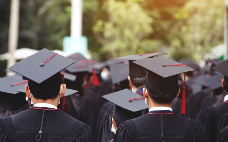 college students wearing graduation caps at graduation ceremony